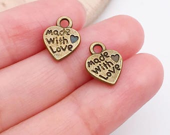 May include: Two antique gold heart-shaped charms with the words "Made with Love" engraved on them.