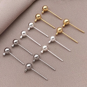 Puede incluir: Un conjunto de 10 postes de pendientes de oro y plata con bolas redondas en la parte superior. Los postes están hechos de metal y están diseñados para su uso en la fabricación de joyas.