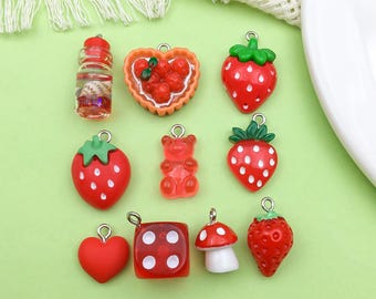 May include: Assortment of red and white resin charms, including a strawberry, a heart, a dice, a mushroom, a gummy bear, a bottle, a pie, and a strawberry. These charms are perfect for adding a touch of whimsy to jewelry, keychains, or other crafts.