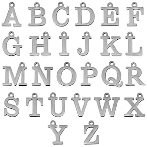 May include: A collection of silver-toned metal alphabet letter charms, each featuring a small circular loop at the top for attachment. The set includes all twenty-six uppercase letters of the English alphabet, arranged in rows against a plain background.