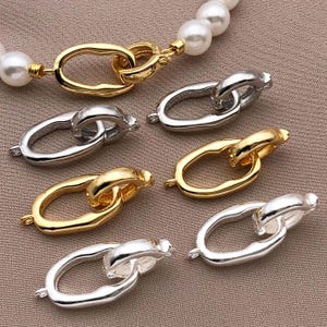 May include: Six different gold and silver metal connector pieces for jewelry making. The connectors are in the shape of a circle with a smaller circle inside. The connectors are all different sizes and have a polished finish.