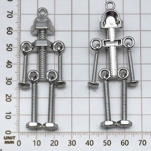 May include: Two silver metal robot figurines with screw details. The robot on the left has a head with two eyes and a screw for a mouth. The robot on the right has a hollow head with a screw in the center.