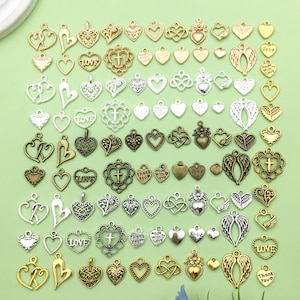 May include: Assortment of silver and gold-toned metal heart-shaped charms with various designs and inscriptions, including "Love", "Thank You", "Made with Love", and a cross.