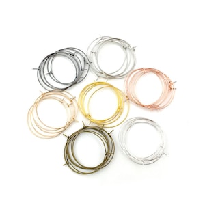Op de afbeelding: Assortiment van oorringbevestigingen in verschillende metaalafwerkingen, waaronder zilver, goud, rosé goud en zwart. De hoepels zijn allemaal van verschillende grootte en perfect voor het maken van oorbellen.