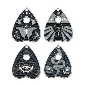 May include: Set of four black and silver charm pendants shaped like a witch's heart, each with a different design: a butterfly, a wine glass, an eye, and a snake.