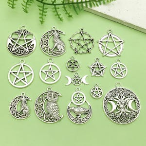 May include: A selection of silver-tone pendants showcasing mystical symbols. Designs include pentagrams, wolves, owls, moons, and ravens. The pendants are round and circular, with Celtic knotwork and star patterns.