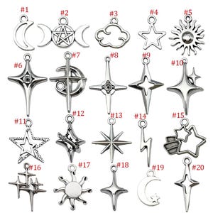 K&ouml;nnte beinhalten: Eine Sammlung von zwanzig silberfarbenen Anh&auml;ngern in verschiedenen himmlischen und symbolischen Formen. Designs umfassen Monde, Sterne, Sonnen, Wolken und Blitze. Jeder Anh&auml;nger hat eine kleine Schlaufe zum Befestigen.