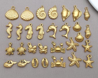 May include: A collection of gold-colored charms in various sea-themed shapes, including seashells, seahorses, dolphins, crabs, starfish, and turtles. Each charm has a small loop for attaching to jewelry or other crafts.