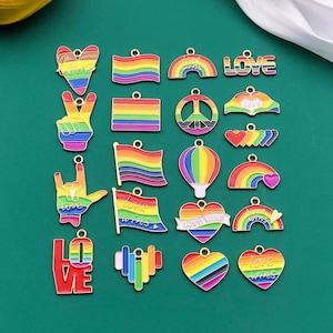 May include: Assortment of rainbow-coloured metal charms with various designs, including peace signs, hearts, flags, and the word "LOVE".