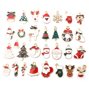 May include: Assortment of 25 gold-tone Christmas charm pendants with enamel details. Charms include Santa Claus, reindeer, snowflakes, candy canes, Christmas trees, bells, stockings, and more.