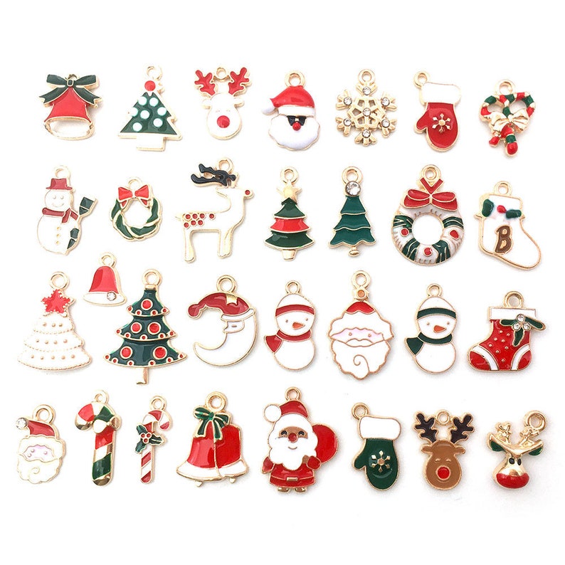 May include: Assortment of 25 gold-tone Christmas charm pendants with enamel details. Charms include Santa Claus, reindeer, snowflakes, candy canes, Christmas trees, bells, stockings, and more.