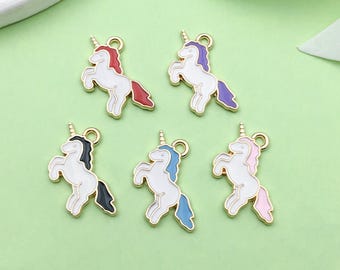 May include: Five gold-coloured unicorn charms with white bodies and different coloured manes and tails. The charms are red, purple, blue, black, and pink.
