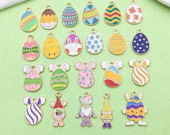 May include: Assortment of 20 gold-tone metal Easter egg charms with various colorful enamel designs. Some charms feature bunny ears, polka dots, stripes, and the words "Happy Easter".