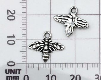 Puede incluir: Dos abalorios de abeja plateados con un diseño detallado. Los abalorios de abeja tienen una superficie texturizada y miden aproximadamente 1,5 cm.