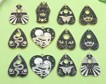 May include: Twelve gold-tone charms in the shape of a heart, a paw print, and a triangle with various designs. The designs include a snake, a skull, a cat, a butterfly, an eye, and a wine glass.