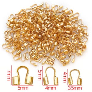 May include: A pile of gold-colored crimp end findings for jewelry making. The image shows various sizes, with the largest measuring 7mm high and 5mm wide. These findings are used to secure the ends of cords or chains.