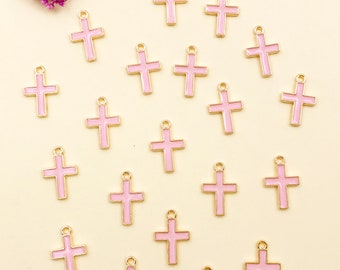 May include: A collection of twenty pink and gold cross charms. The charms are small and delicate, perfect for adding a touch of faith to jewelry or crafts.