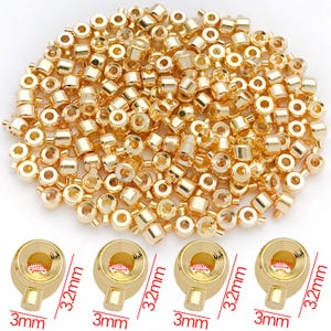 Puede incluir: Una colección de pequeñas cuentas y cierres metálicos dorados y brillantes. Los cierres miden 3 mm de ancho y 3,2 mm de largo, con una abertura de 0,8 mm. Las cuentas son cilíndricas. Ideal para la creación de joyas.