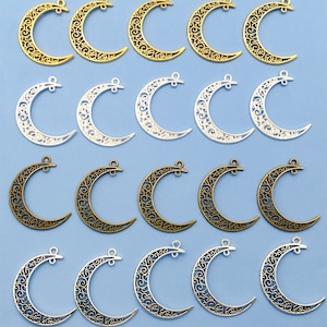 May include: A set of 20 silver and gold crescent moon charms with intricate filigree designs. The charms are perfect for jewelry making, scrapbooking, and other craft projects.
