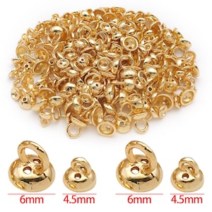 May include: A collection of gold-coloured metal jewellery findings, including bail beads and round beads with loops. The image also shows four individual beads, two measuring 6mm and two measuring 4.5mm in diameter.