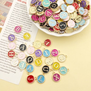 26 piezas mezcla de colores aleatorios A-Z 26 letras del alfabeto set-2 caras etiqueta redonda encanto esmalte inicial encantos oro tono esmalte letra encantos