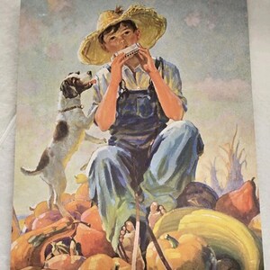 May include: A vintage print depicts a young person playing a harmonica while seated on pumpkins, wearing overalls and a straw hat. A dog stands nearby, looking up. The artwork has a warm color palette with a rural theme.