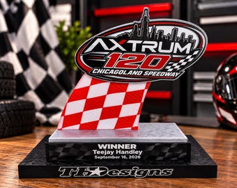 Puede incluir: Un trofeo de carreras con una placa ovalada con el texto AXTRUM 120 CHICAGOLAND SPEEDWAY y una silueta del horizonte de Chicago. Debajo hay un diseño de bandera a cuadros roja y blanca, una base con el texto WINNER Teejay Handley September 16, 2026 y una base negra inferior con el texto TF Designs.