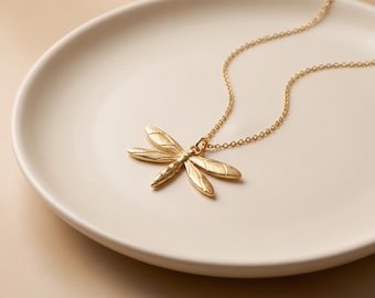 Vergulde hanger met libelle, minimalistische sieraden geïnspireerd op de natuur.