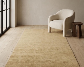 Halmbeige handvävd matta, ljusgyllene neutral matta, minimalistisk ullmatta, skandinavisk vardagsrumsmatta, mjuk enfärgad golvmatta