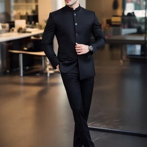 Puede incluir: Un traje negro con cuello mao, combinado con zapatos negros y gafas de sol. El traje tiene un corte entallado y está abotonado por delante. Se ve un reloj en la muñeca izquierda.