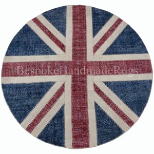 May include: A circular rug featuring a patchwork design of the Union Jack flag in shades of deep blue, faded red, and off-white. The surface displays a distressed texture with visible stitching connecting the fabric segments. Text reads BespokeHandmadeRugs.