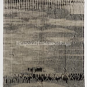 May include: A rectangular rug with a vertical striped pattern in shades of black, gray, and off-white. The rug features a textured design with a darker band near the bottom. The text "Bespoke Handmade Rugs" is visible.