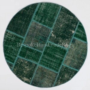 May include: A circular patchwork rug featuring various shades of green and muted gray-green tones. The rug is composed of rectangular segments stitched together with visible seams. The text BespokeHandmadeRugs is centered on the rug.