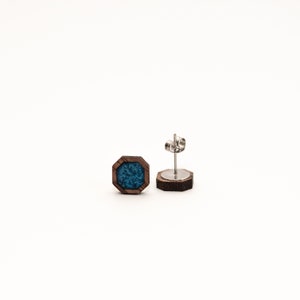 Peut inclure: Boucles d'oreilles &agrave; clous octogonales avec un cadre en bois fonc&eacute; et un centre en r&eacute;sine turquoise. Une boucle d'oreille est pr&eacute;sent&eacute;e avec la tige et le fermoir, l'autre est face visible. Sur fond blanc.