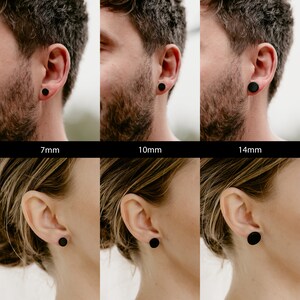 Pu&ograve; includere: Tre paia di orecchini a bottone rotondi neri di diverse dimensioni, 7 mm, 10 mm e 14 mm, mostrati sulle orecchie dei modelli.