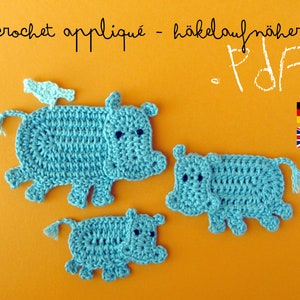 May include: Three crocheted blue hippopotamus appliques on a bright orange background. The largest hippo has a small blue bird on its back. The text "crochet applique - häkelaufnäher - PDF" is at the top of the image. The flags of Germany and the United Kingdom are in the upper right corner.