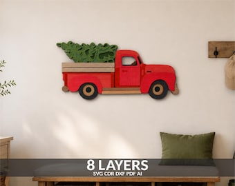 May include: A multi-layered wooden wall art piece depicting a red pickup truck carrying a green Christmas tree in its bed. The truck features a red cab and body, a light-colored wooden truck bed, and black wheels. The design consists of 8 layers.