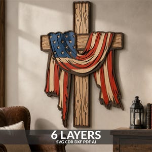 May include: A multi-layered wooden wall art piece featuring a cross draped with an American flag design. The artwork consists of six distinct layers with wood grain textures, red, white, and blue colours, and text at the bottom reading 6 LAYERS SVG CDR DXF PDF AI.