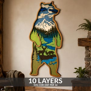 May include: A multi-layered wooden wall art piece shaped like a standing bear. The interior features a landscape with a mountain, forest, river, and deer silhouettes. The design includes 10 layers of wood with blue, green, and natural wood tones.