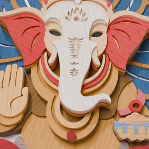 May include: A multi-layered wooden wall art piece depicting the deity Ganesha. The design features a white face and trunk, red ears, and blue accents. Ganesha is shown with an open palm gesture, holding a pink lotus flower and a small bowl.