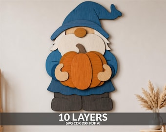 Pode incluir: Uma peça de arte de parede em madeira em camadas representando um gnomo com chapéu e casaco azuis, segurando uma abóbora laranja. O gnomo tem uma barba clara e botas cinza-escuras. O texto 10 LAYERS SVG CDR DXF PDF AI está na parte inferior.