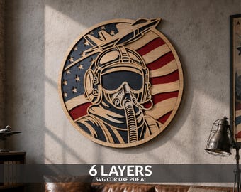 May include: A circular multi-layered wooden wall art piece featuring a fighter pilot wearing a helmet and oxygen mask, set against a stylized American flag background with a jet silhouette at the top, rendered in natural wood, red, and blue tones.