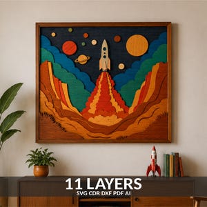 May include: A multi-layered wooden wall art piece featuring a rocket ship launching into space. The design includes a dark blue sky, orange and yellow planets, and layered terrain in shades of brown, orange, and green. Text reads 11 LAYERS SVG CDR DXF PDF AI.