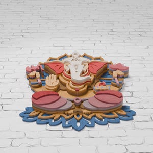 May include: A multi-layered wooden wall art piece depicting the deity Ganesha in a seated position. The design features a white face, pink ears, and a tan body, all resting on a blue lotus flower base with intricate cut-out details and stacked layers.