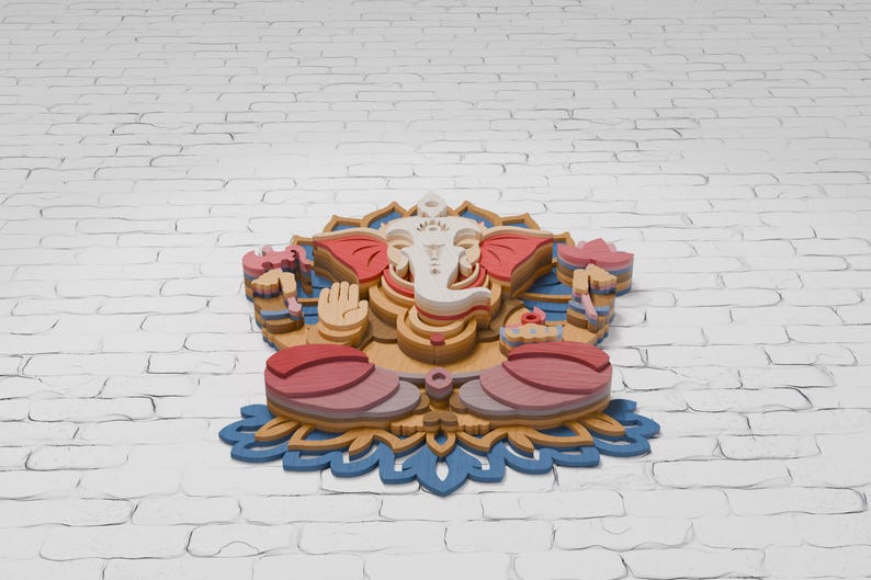 May include: A multi-layered wooden wall art piece depicting the deity Ganesha in a seated position. The design features a white face, pink ears, and a tan body, all resting on a blue lotus flower base with intricate cut-out details and stacked layers.