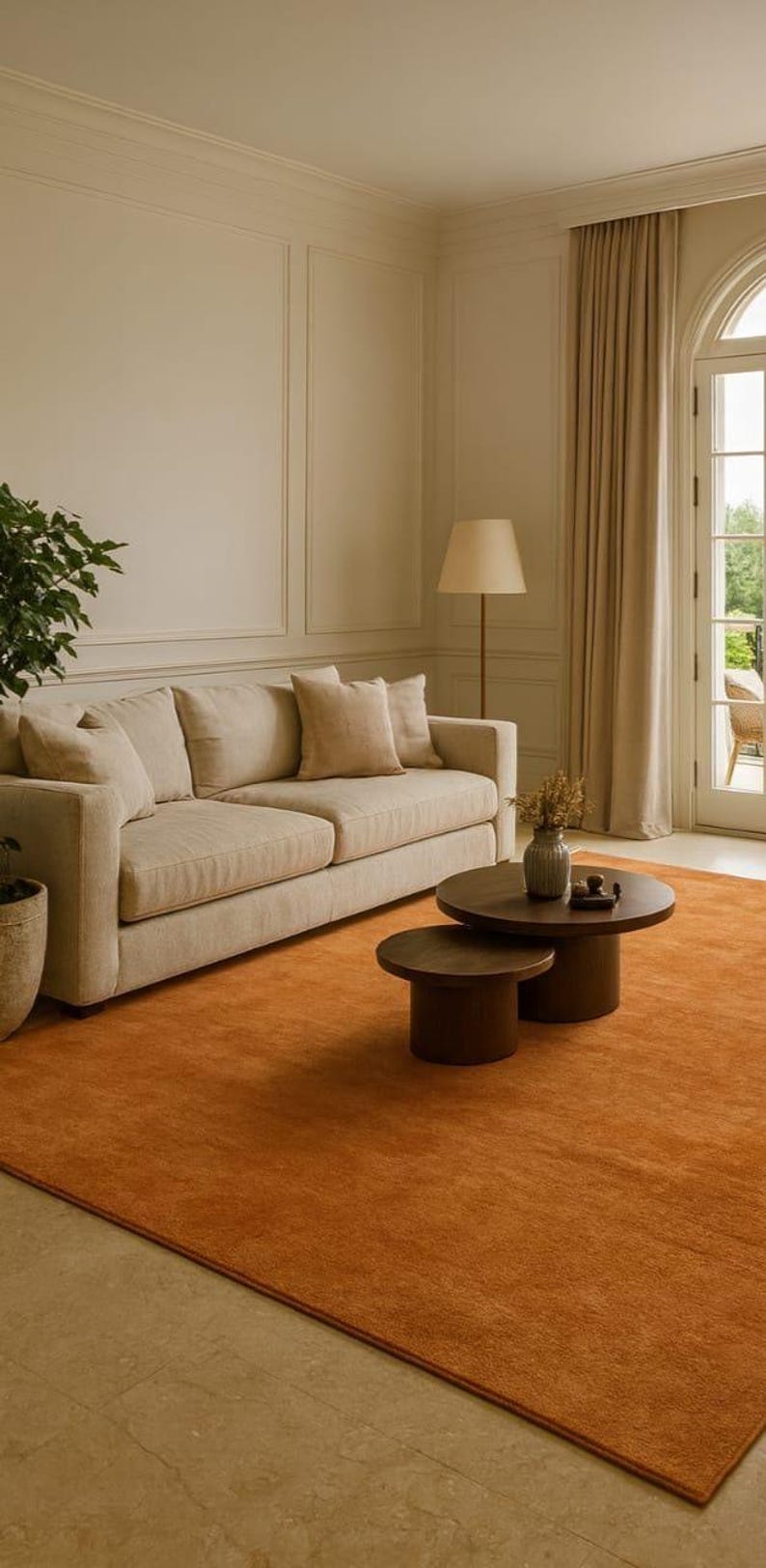 Puede incluir: Un sal&oacute;n con un sof&aacute; beige, cojines y una mesa de centro redonda. Una alfombra naranja vibrante cubre el suelo. Tambi&eacute;n hay una l&aacute;mpara de pie y una planta en maceta. La habitaci&oacute;n tiene una paleta de colores neutros.