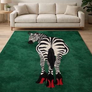 Könnte beinhalten: Grüner Teppich mit Zebradesign. Das Zebra ist von hinten zu sehen und trägt schwarze High Heels mit roten Sohlen. Der Teppich befindet sich in einem Wohnzimmer mit weißem Sofa und neutralen Wänden. Ca. 200 cm x 300 cm groß.