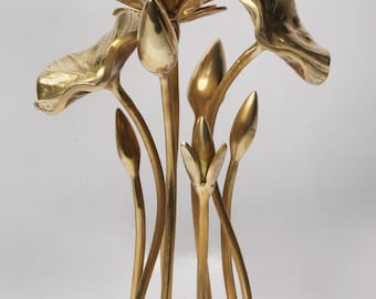 May include: A golden metal sculpture of a lotus flower with multiple leaves and buds. The sculpture has a round base and is made of a shiny, reflective metal. The lotus flower is a symbol of purity and enlightenment.