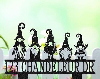 May include: Black metal garden stake with five gnome figures above a bar displaying the address "123 CHANDELEUR DR". The gnomes have different beard and hat designs. The lettering is white.