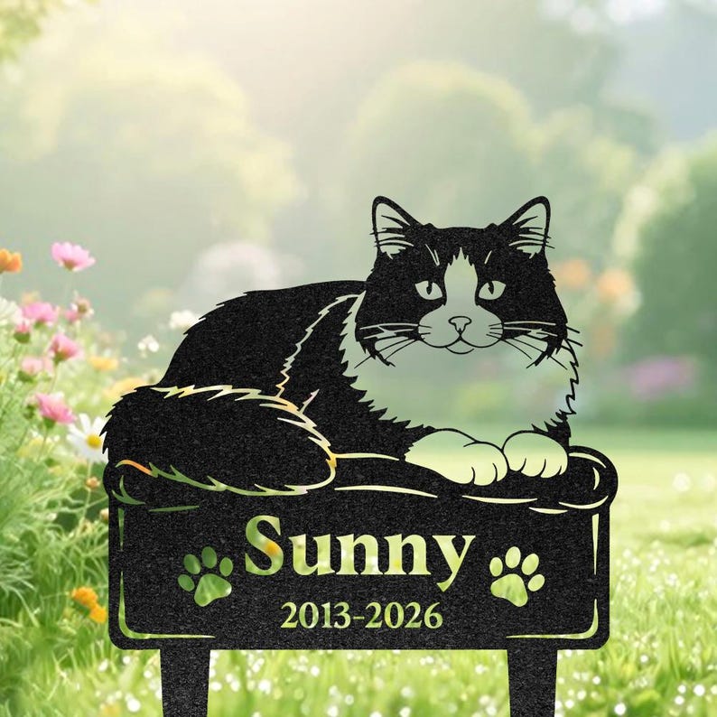 May include: A black and white metal cat memorial garden stake featuring a resting cat silhouette. The rectangular base displays the name Sunny in a serif font, two paw print icons, and the years 2013-2026 engraved in a clear, legible style.
